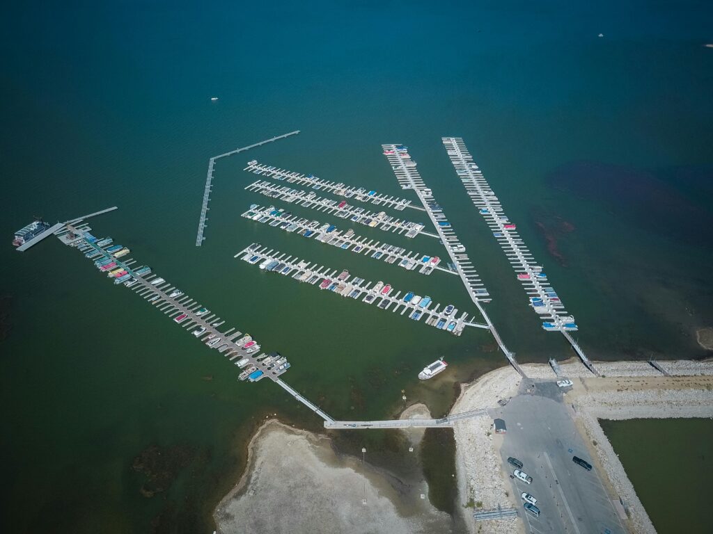 aerial view of a marina with multiple boats docked in blue and green waters.