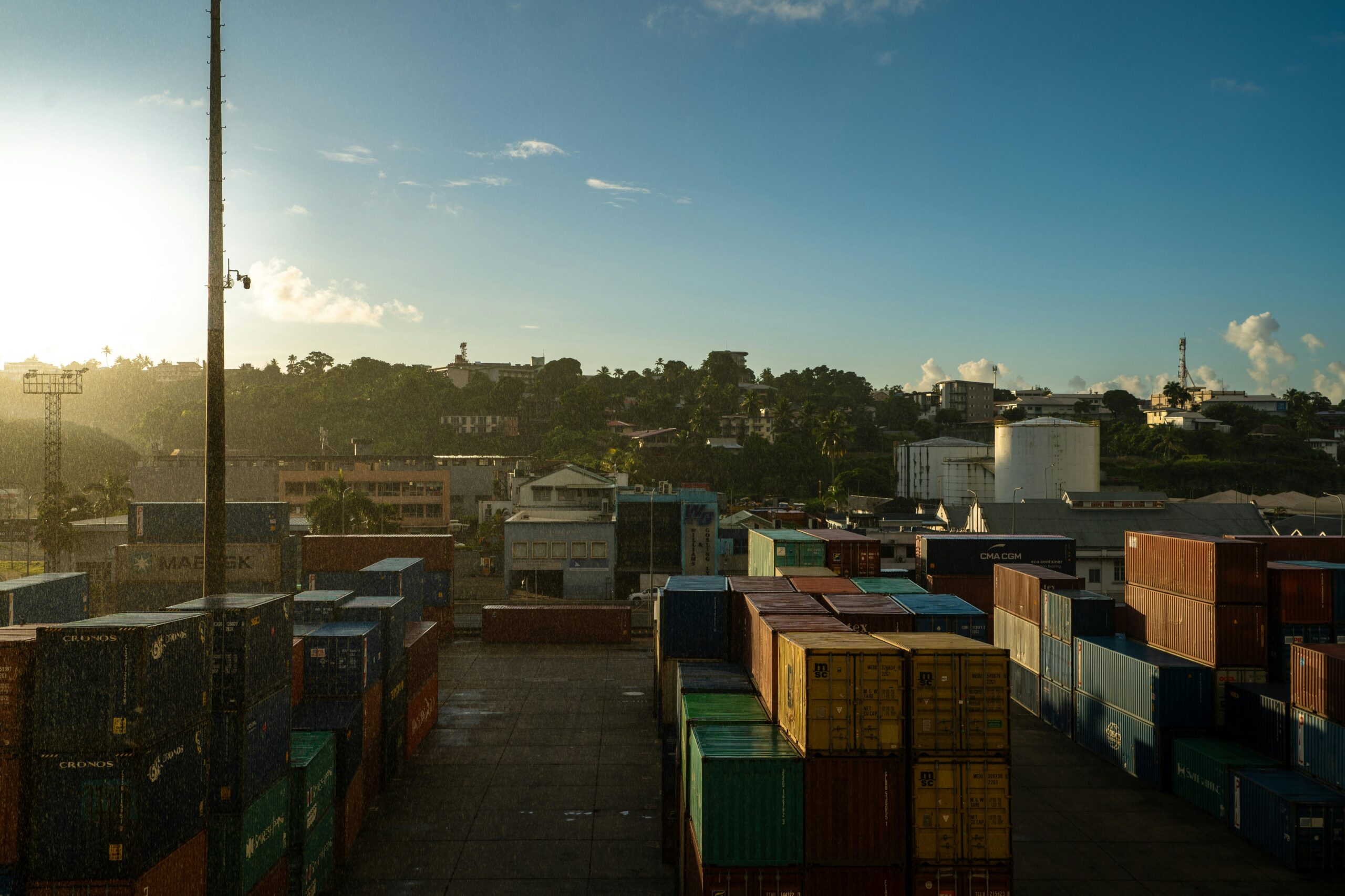 shipping containers at suva port in fiji with sunrise, showcasing a vibrant industrial landscape.