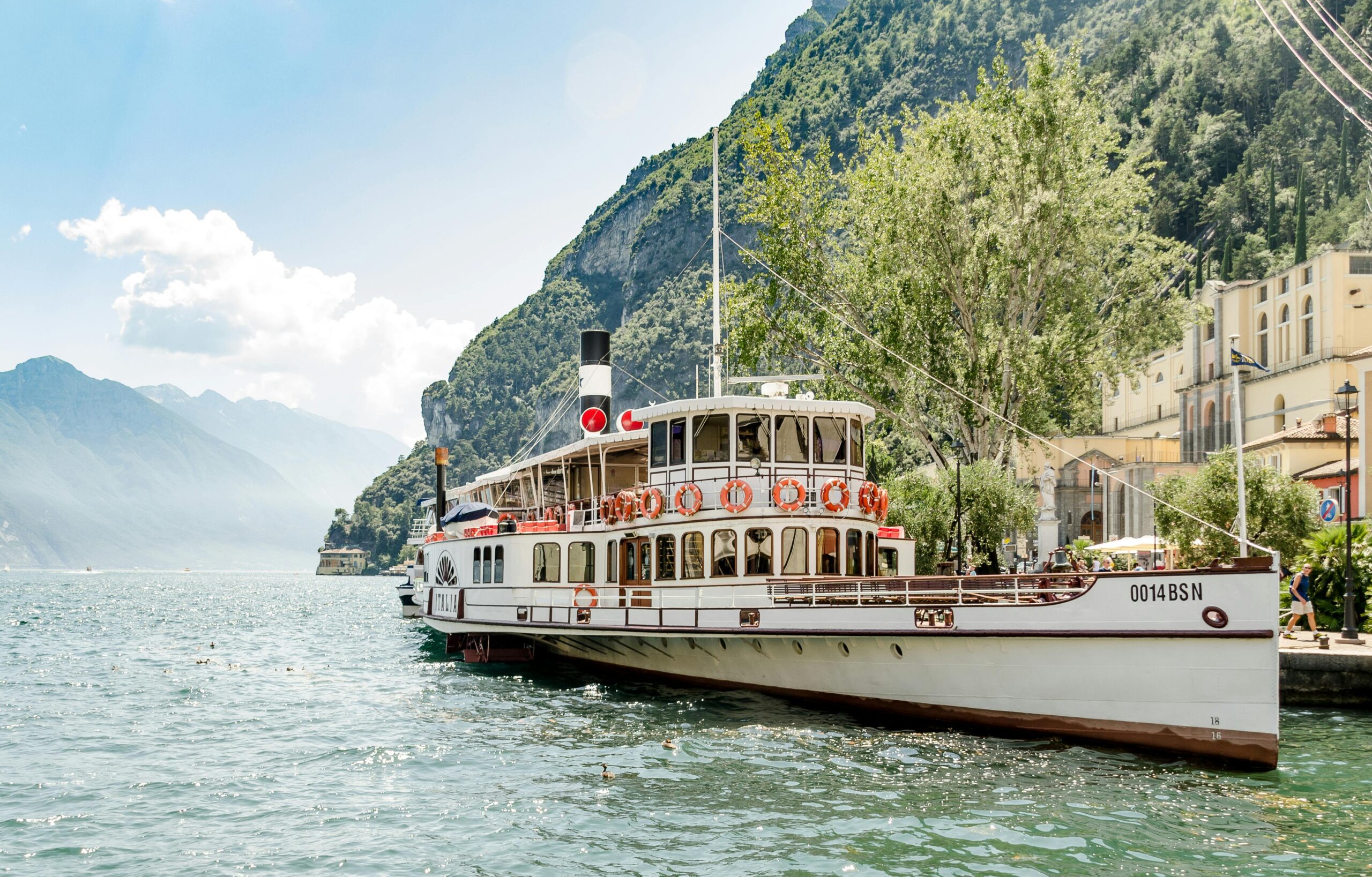 a classic ferry boat docked at riva del garda, showcasing the beauty of lake garda in italy.