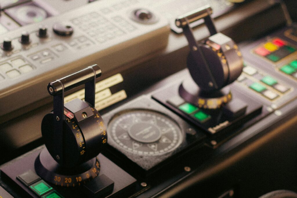 detailed view of control levers and compass on a ship's bridge, showcasing navigational technology.