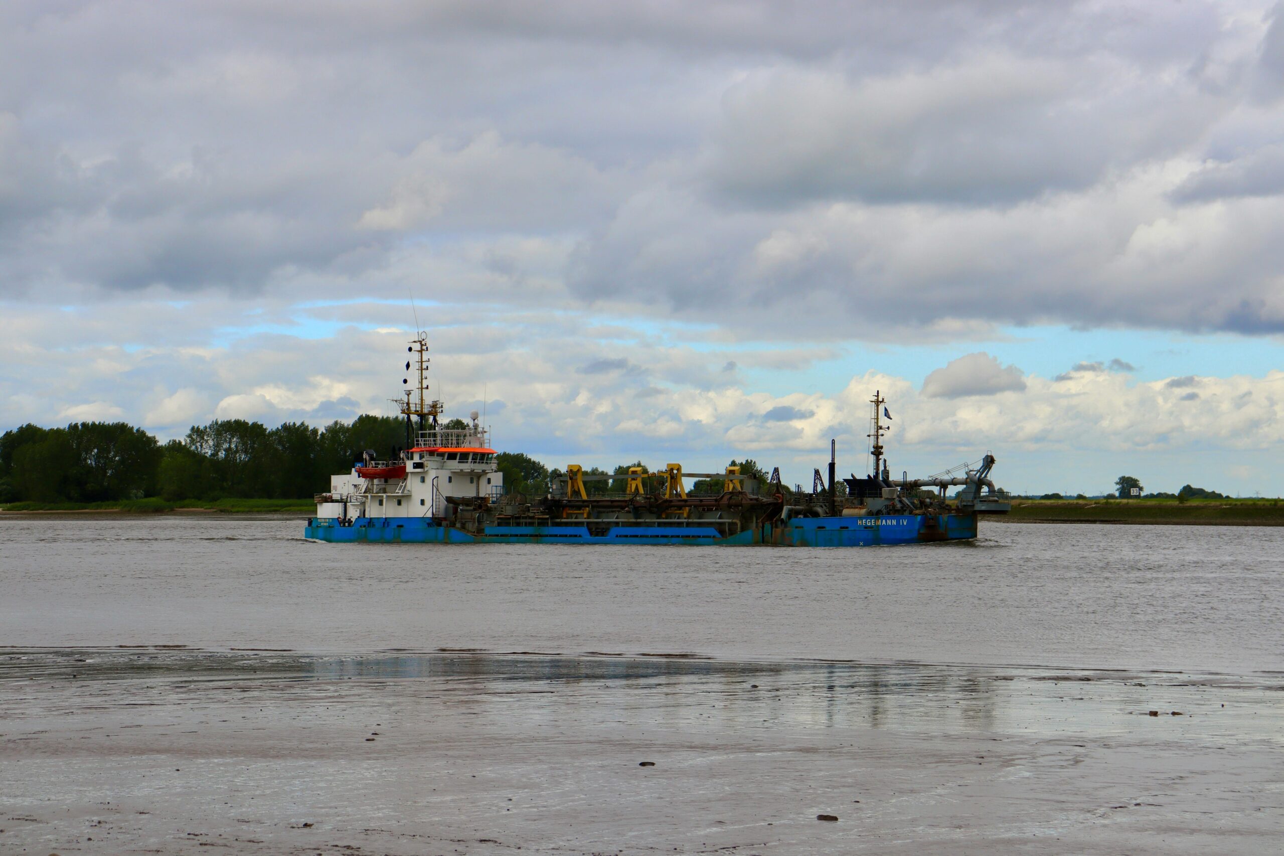 a tugboat navigating a calm sea under a cloudy sky, highlighting maritime industry.