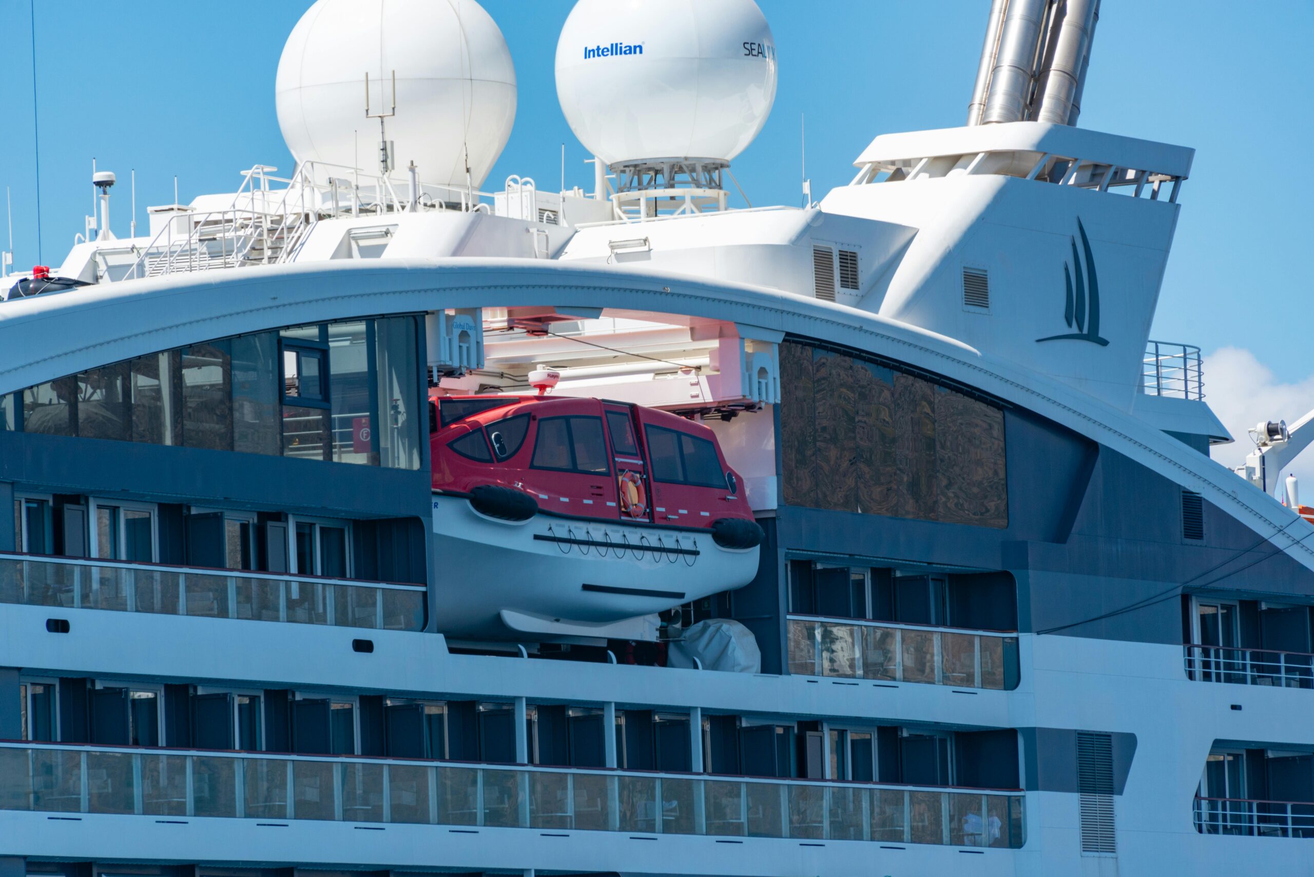 close-up of a modern luxury cruise ship featuring a rescue boat and sleek design.