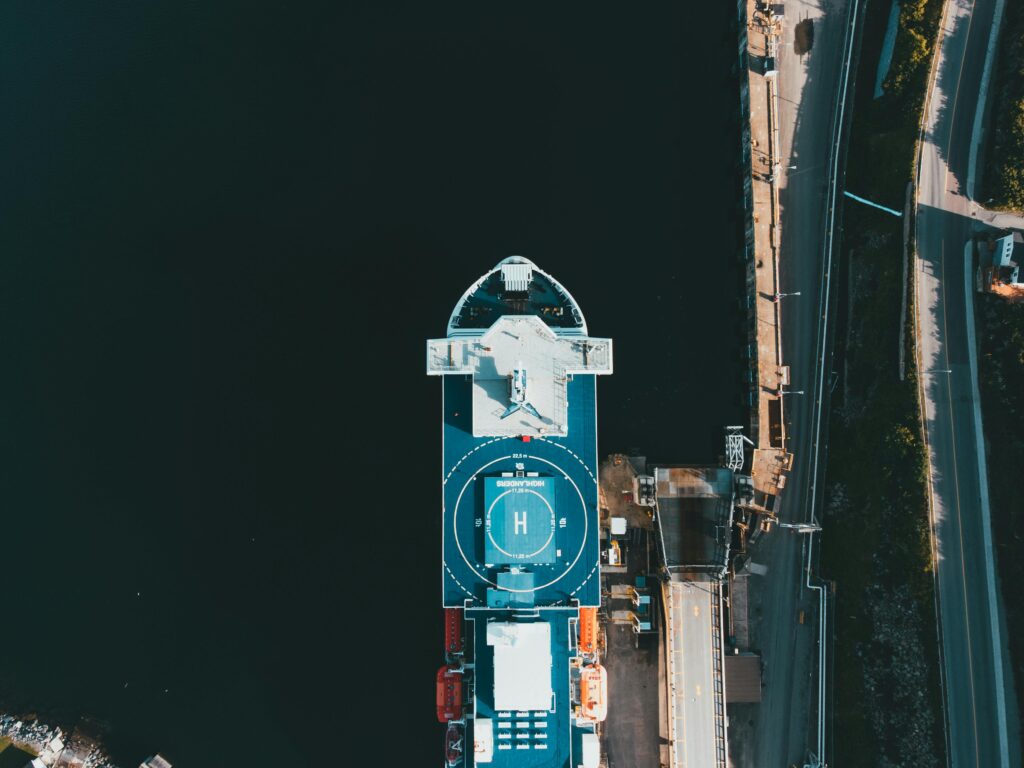 drone shot capturing a ship docked at a quayside, showcasing a clear birds-eye view.