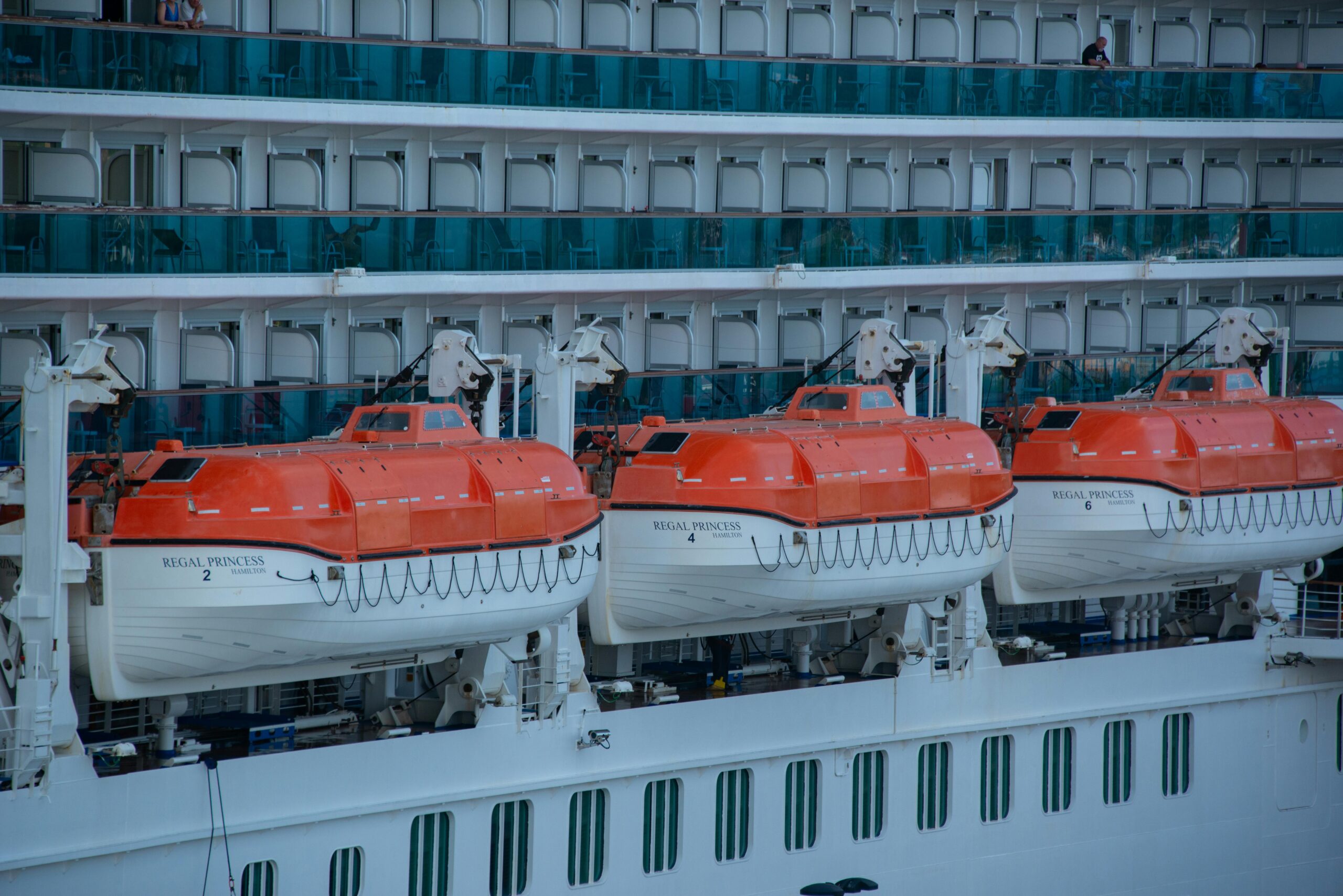 close-up view of lifeboats on a cruise ship, highlighting safety equipment.