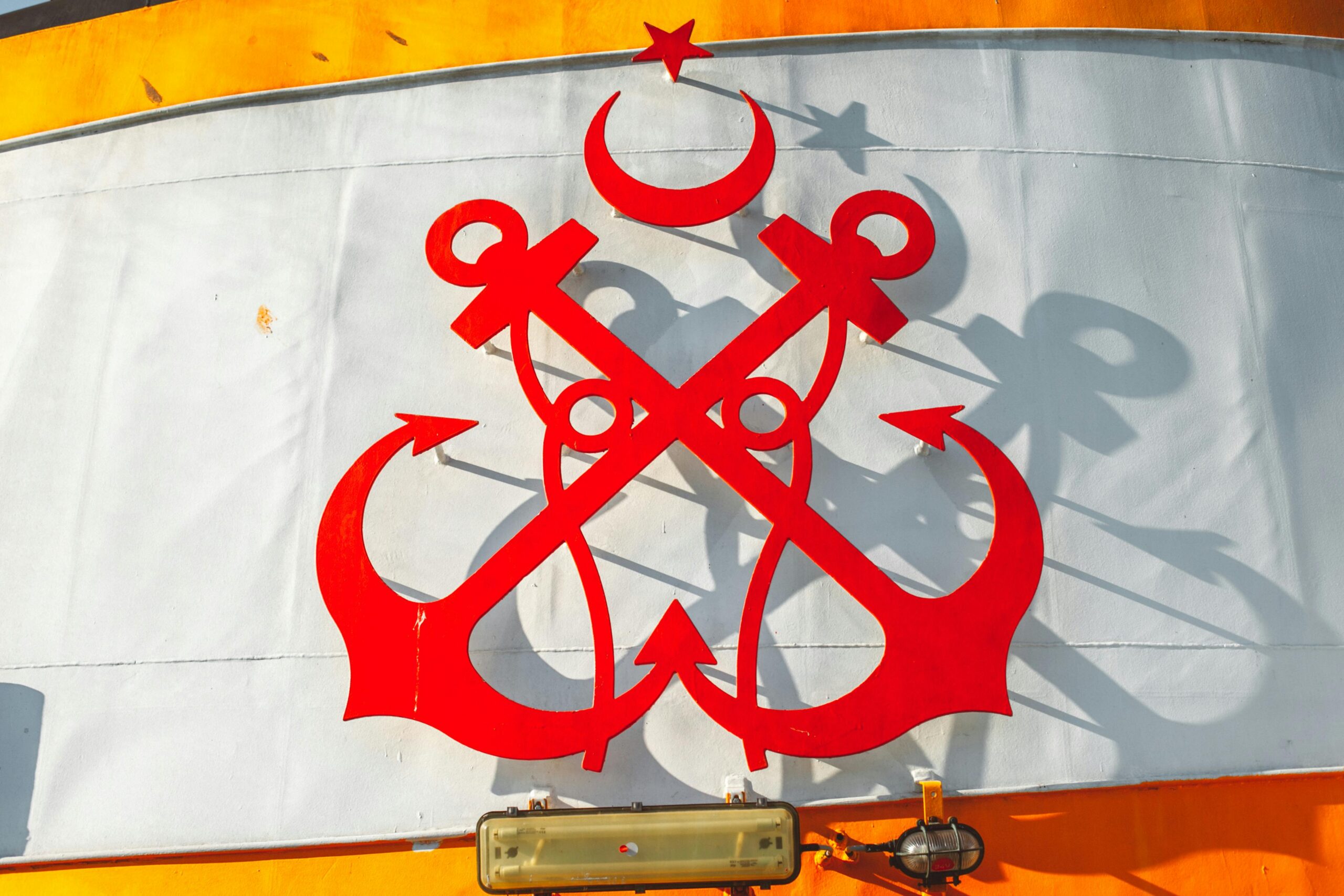bold red anchor design on a ship's funnel against a vibrant background.