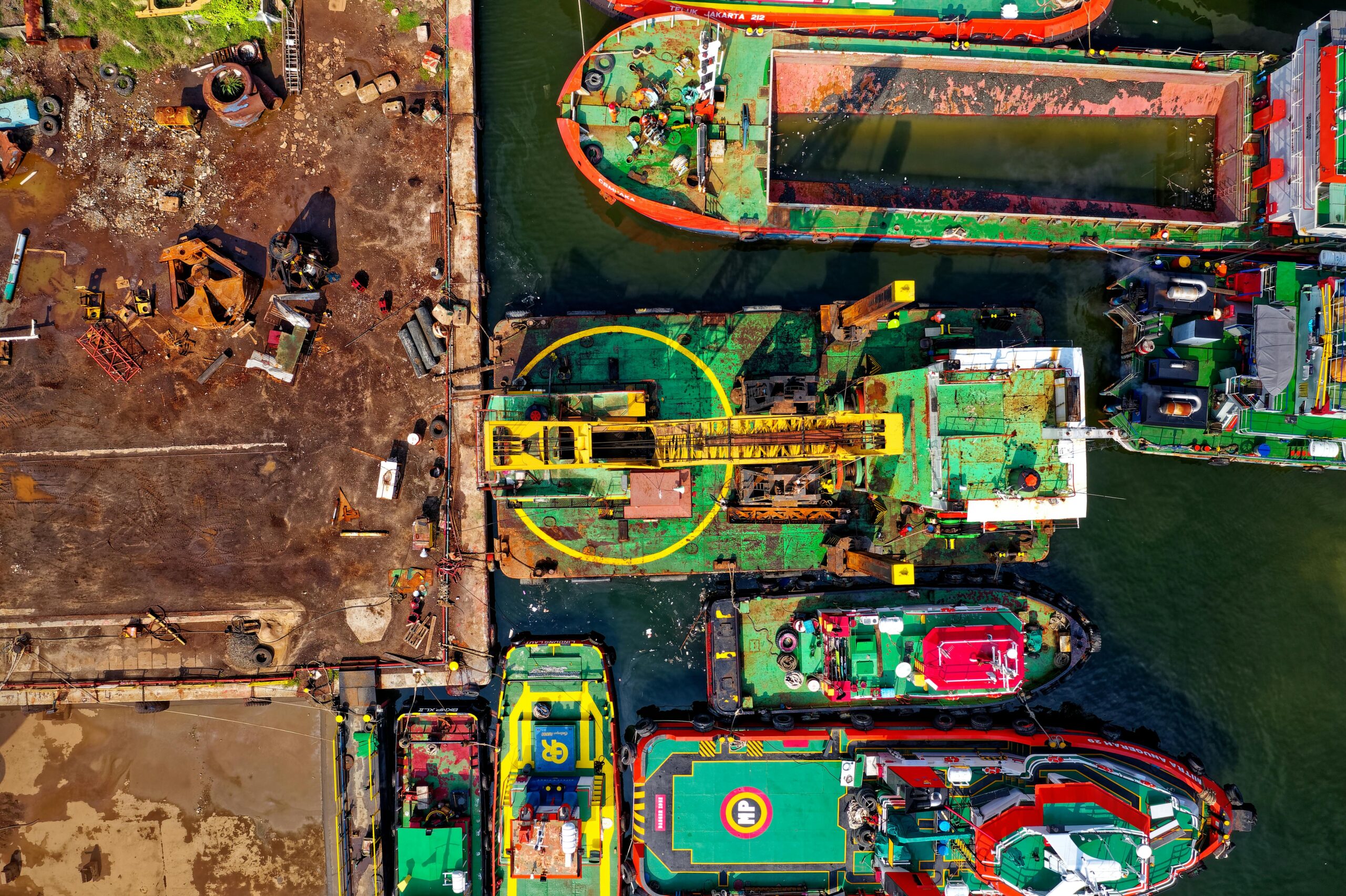 aerial image showcasing a vibrant industrial dock featuring multiple colorful vessels and cranes.