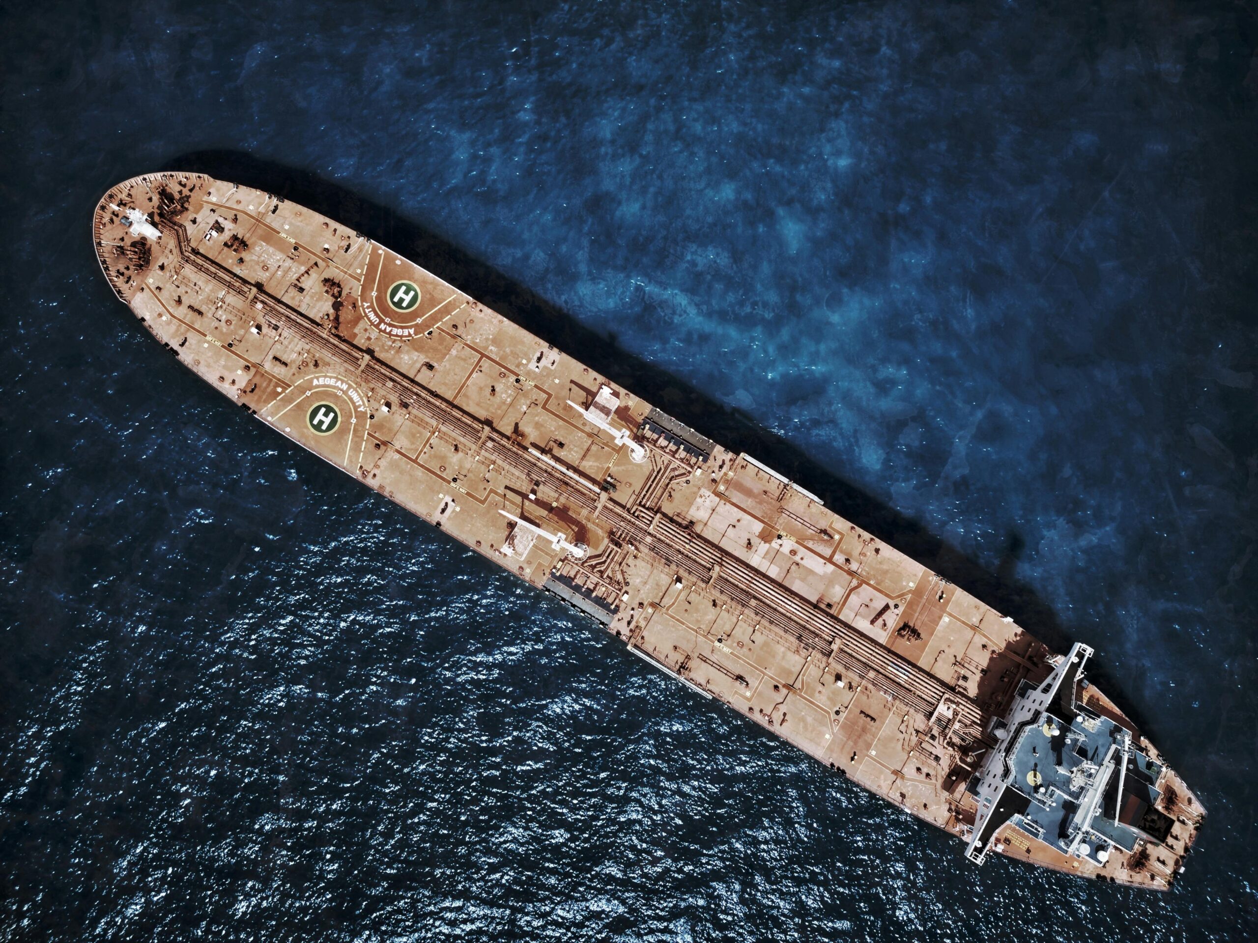 drone shot of large tanker ship with helipads in ocean waters.