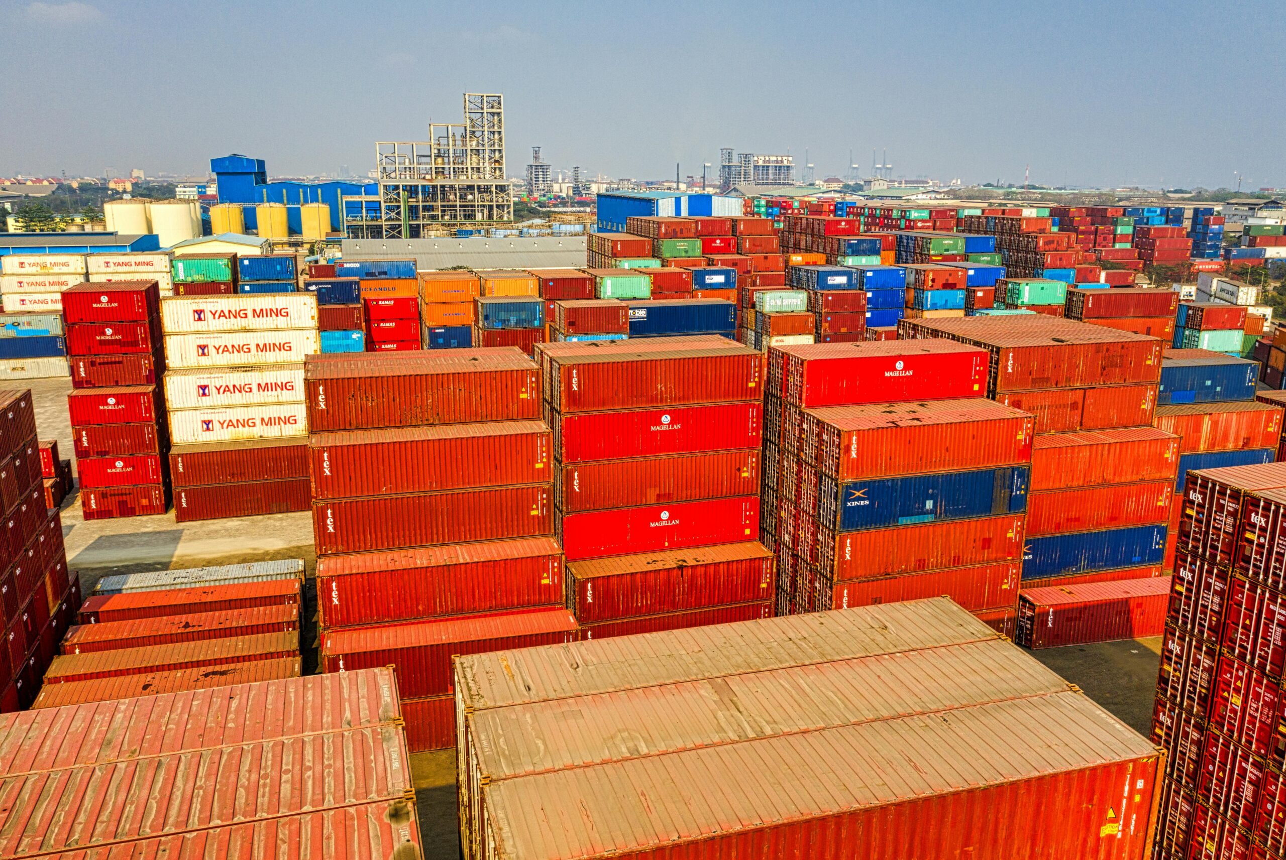 drone shot showcasing stacked colorful cargo containers at jakarta port.