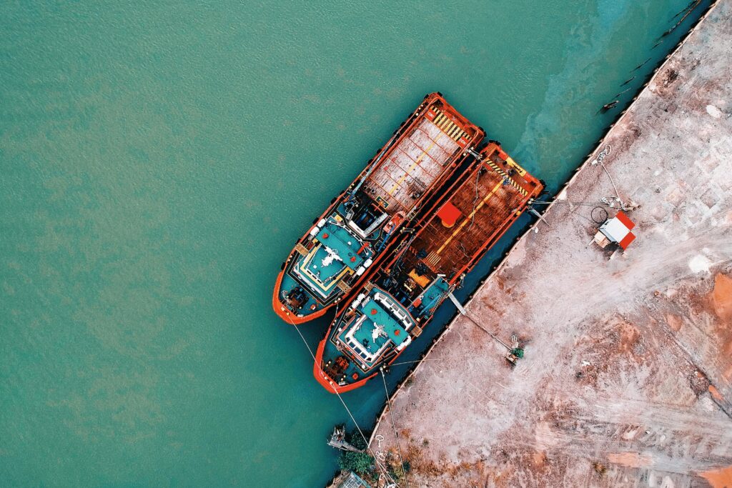 aerial shot of industrial ships docked at a harbor, showing vivid color contrasts and rustic elements.