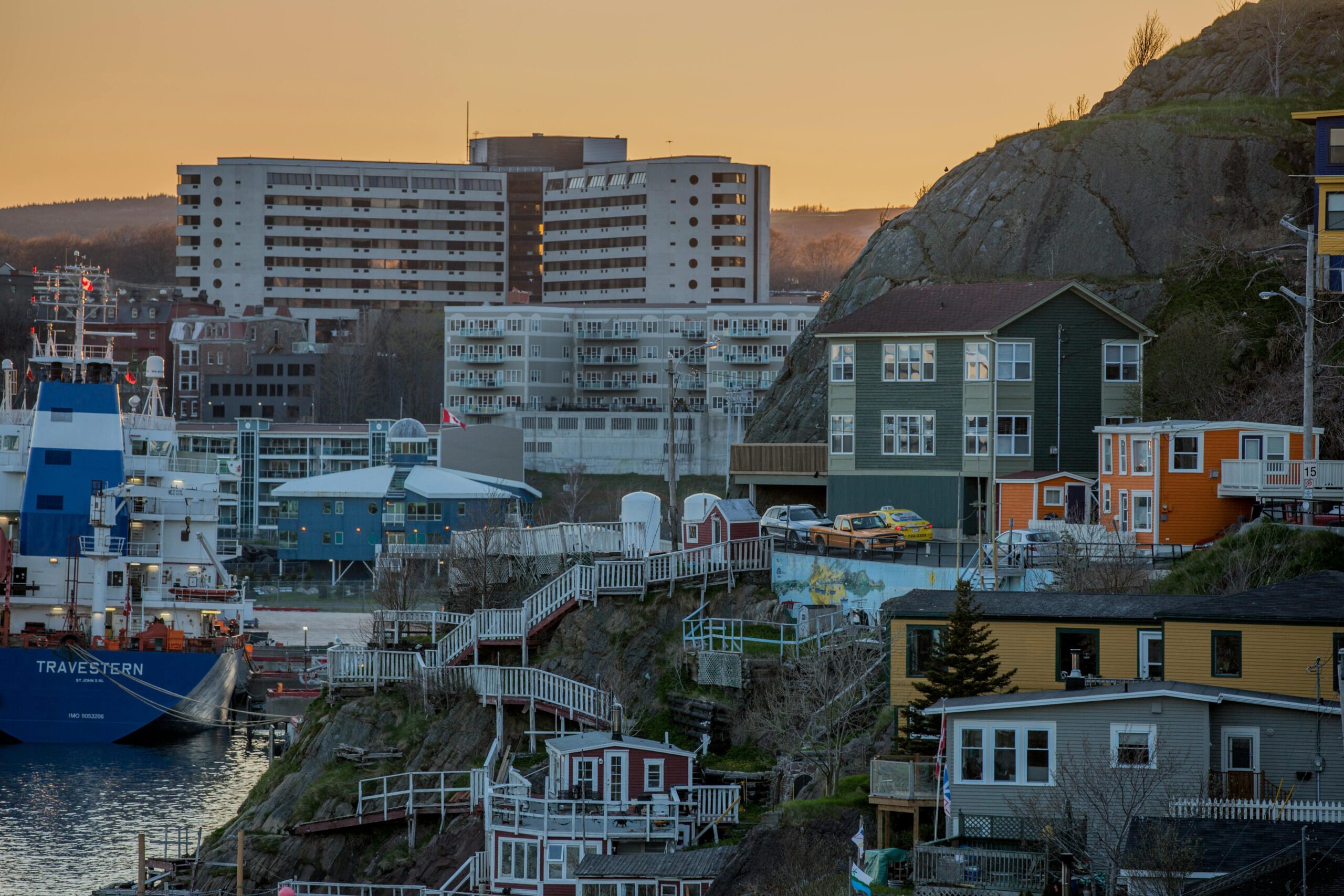 vibrant coastal town at sunset with colorful houses and harbor view.