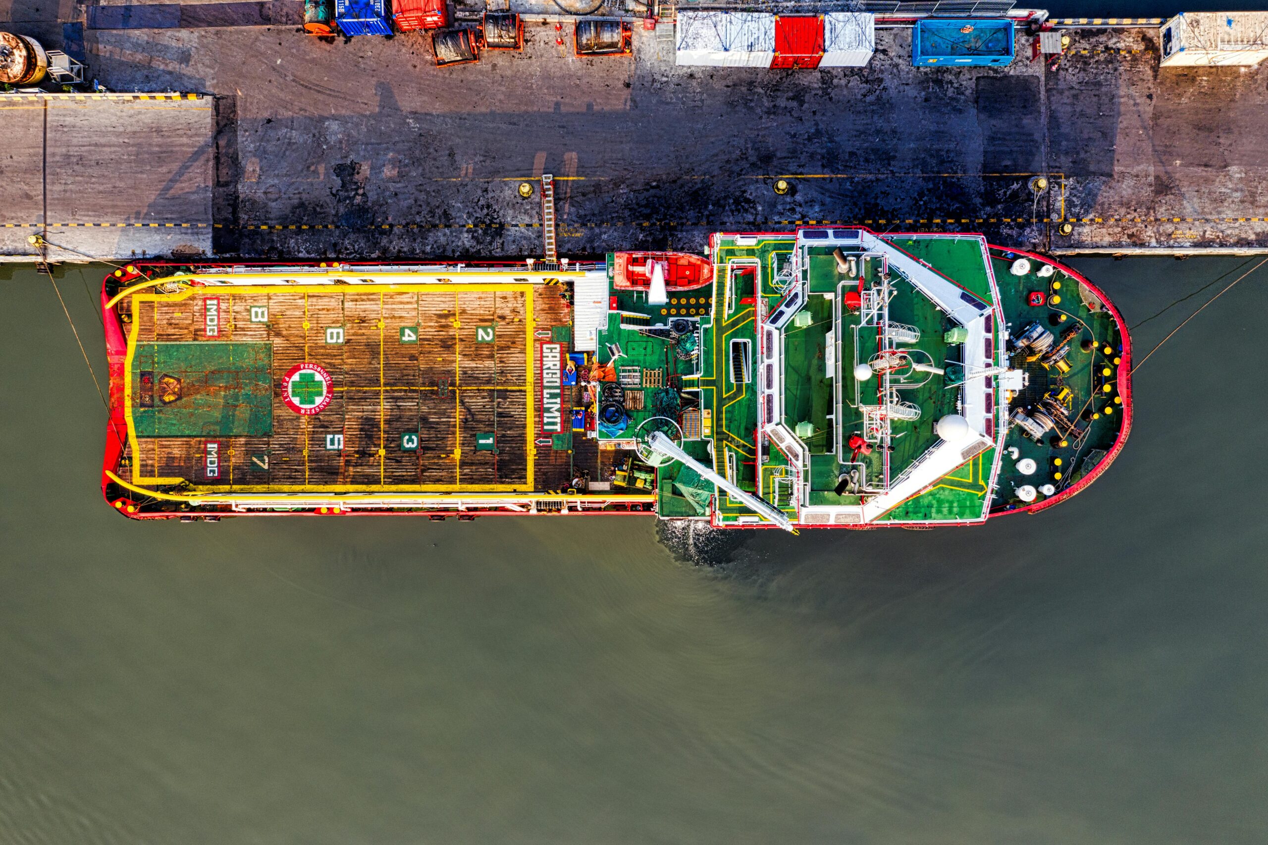top-down view of a colorful cargo ship docked in jakarta, showcasing logistics and transportation.