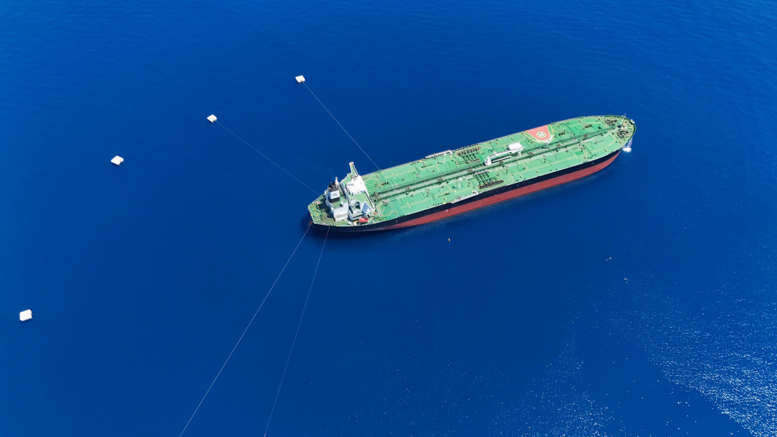 aerial shot of a tanker ship anchored in the vibrant blue ligurian sea near vado ligure, italy.